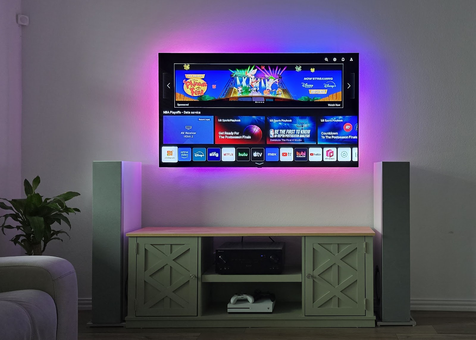 A wall-mounted TV with ambient lighting, installed by Smart Fixer Pro